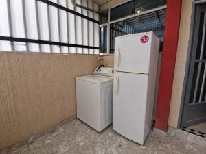 通哈的住宿－aparta estudio independiente norte Tunja，客房内的白色冰箱和洗衣机