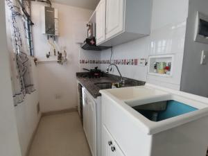 通哈的住宿－aparta estudio independiente norte Tunja，白色的厨房设有水槽和台面