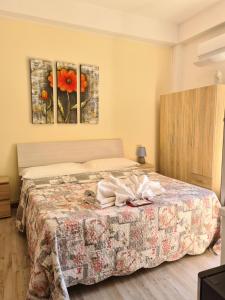 a bedroom with a bed with a flower painting on the wall at Bella Taormina in Taormina