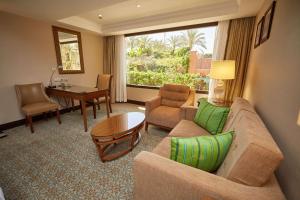Hilton Alexandria King's Ranch Hotel في الإسكندرية: غرفة معيشة مع أريكة وطاولة
