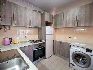 a kitchen with wooden cabinets and a washer and dryer at new sunny house! your home Lisbon apartment in Lisbon
