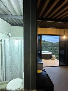a bathroom with a tub and a toilet and a window at Glamping monterrio in Santa Rosa de Cabal