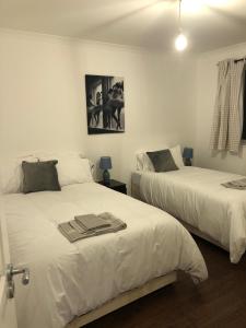 a bedroom with two beds with towels on them at Mill Hill Modern 3 Bedroom Apartment in Mill Hill