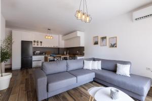 Boho Central Apartment في تيرانا: غرفة معيشة مع أريكة زرقاء ومطبخ