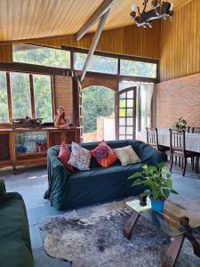 a living room with a green couch and a table at Chácara ladeira de Pedra in Salesópolis