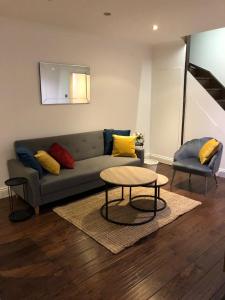 a living room with a couch and a table at Mill Hill Modern 3 Bedroom Apartment in Mill Hill