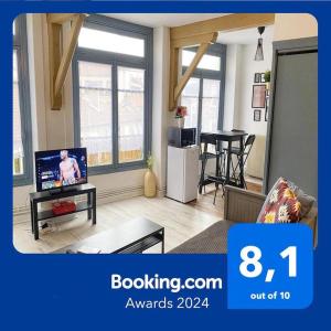 een woonkamer met een televisie en een woonkamer met een tafel bij 015 CHIC & COSY STUDIO 41m2 HYPERCENTRE WIFI SMART TV NETFLIX in Saint-Étienne