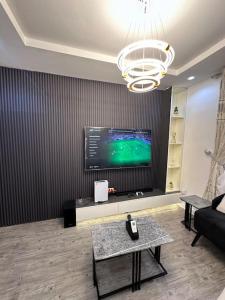 a living room with a flat screen tv on a wall at Cheapest luxury 1 bedroom apartment in Katampe Ext in Gwarinpa