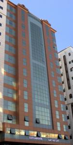 a tall building with a lot of windows at فندق لؤلؤة العنود مكة Loulouat Al Anood Hotel Mecca in Makkah