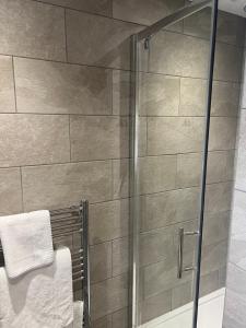a shower with a glass door in a bathroom at Priory Tearooms Burford with Rooms in Burford