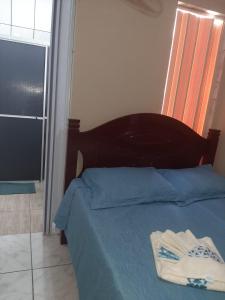 a bedroom with a bed with blue sheets and a window at Apartamentos Central in Triunfo