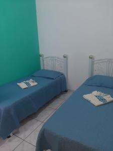 dwa łóżka w pokoju z niebieską pościelą w obiekcie Apartamentos Central w mieście Triunfo