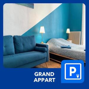 een blauwe bank en een bed in een kamer bij 020 CHIC & COSY GRAND APPART 57m2 HYPERCENTRE WIFI SMART TV NETFLIX in Saint-Étienne