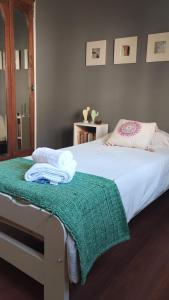 a bedroom with a bed with a green blanket on it at Casa Las Clivias in Lobos