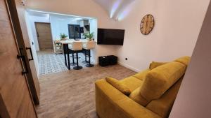 a living room with a couch and a clock on the wall at Bailén 3 in Cáceres