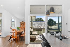 een keuken en eetkamer met uitzicht op een huis bij The Daydreamer - Mangawhai Heads Holiday Home in Mangawhai