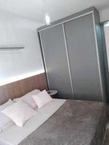 een bed met twee kussens in een kamer bij Apartamento Aconchegante para duas pessoas in Gravataí