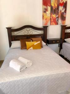 a bedroom with a bed with two towels on it at Mayan Plaza Hermosa Habitación a 3 cuadras del Parque in Copán Ruinas