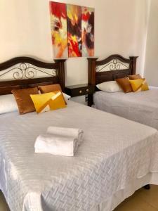 a bedroom with two beds with towels on them at Mayan Plaza Hermosa Habitación a 3 cuadras del Parque in Copán Ruinas