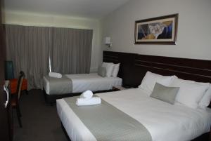 um quarto de hotel com duas camas e uma janela em Auckland Airport Kiwi Motel em Auckland