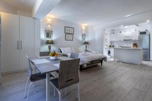 Una sala de estar con una cama, una mesa y sillas. en Bahar ic-Caghaq Apartment with private drive-in, equidistant from Sliema and St. Paul's Bay, en Naxxar