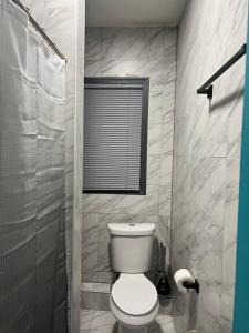 een badkamer met een wit toilet en een raam bij Vintage Luxury 2 Bedroom in Newark