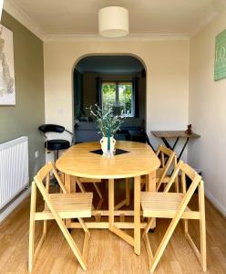 a dining room table and chairs with a vase on it at 3 Bedroom Detached house in Wellingborough