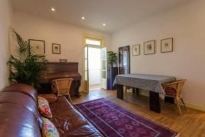 - un salon avec un canapé et un piano dans l'établissement Be Local - Charming flat with 2 bedrooms on Lisbon's 7th hill, à Lisbonne