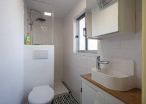 La salle de bains blanche est pourvue d'un lavabo et de toilettes. dans l'établissement Be Local - Charming flat with 2 bedrooms on Lisbon's 7th hill, à Lisbonne