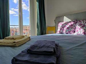 - un lit avec des serviettes et une fenêtre dans l'établissement Be Local - Charming flat with 2 bedrooms on Lisbon's 7th hill, à Lisbonne
