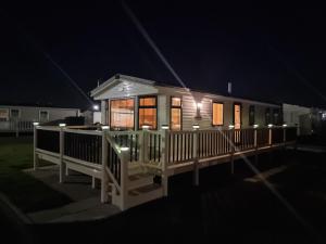 a small house with a porch at night at Palm Grove 110 in Chapel Saint Leonards