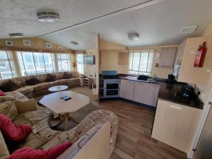 a living room with a couch and a table at Palm Grove 110 in Chapel Saint Leonards