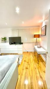 a bedroom with a bed and a table and a television at A beautiful stylish 2 Bedroom Apartment -City of London in London