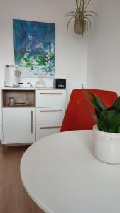 a living room with a white table and a red couch at Zimmer im Herzen Gößweinsteins in Gößweinstein