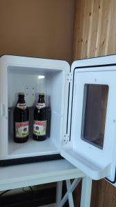 two bottles of beer are inside of a refrigerator at Zimmer im Herzen Gößweinsteins in Gößweinstein