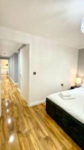 a bedroom with a bed and a wooden floor at A beautiful stylish 2 Bedroom Apartment -City of London in London