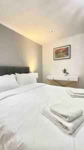 a bedroom with a white bed with towels on it at A beautiful stylish 2 Bedroom Apartment -City of London in London