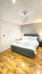 a bedroom with a large bed with a chandelier at A beautiful stylish 2 Bedroom Apartment -City of London in London
