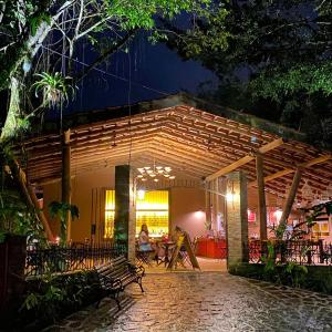 un patio de un restaurante por la noche en alua pousada ventos de camburi, en Camburi