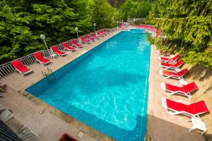 una vista aérea de una gran piscina con sillas rojas en Diva Hotel & Thermal Pool, en Chiflik