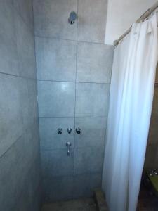 a shower with a white shower curtain in a bathroom at La casa Roja in San Carlos