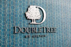a tree on a blue wall with the wordsdroubletree by illustration at DoubleTree by Hilton Hotel Newcastle International Airport in Newcastle upon Tyne
