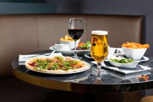 a table with a pizza and two glasses of wine at DoubleTree by Hilton Hotel Newcastle International Airport in Newcastle upon Tyne