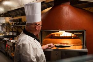 a chef standing in front of a pizza oven at DoubleTree by Hilton Hotel Newcastle International Airport in Newcastle upon Tyne