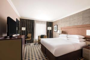 a hotel room with a large bed and a television at DoubleTree by Hilton Hotel Newcastle International Airport in Newcastle upon Tyne