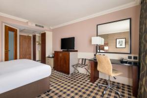 a hotel room with a bed and a desk and a television at DoubleTree by Hilton Hotel Newcastle International Airport in Newcastle upon Tyne