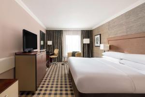 a hotel room with a bed and a flat screen tv at DoubleTree by Hilton Hotel Newcastle International Airport in Newcastle upon Tyne