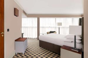 a bedroom with a large white bed and a desk at DoubleTree by Hilton Hotel Newcastle International Airport in Newcastle upon Tyne