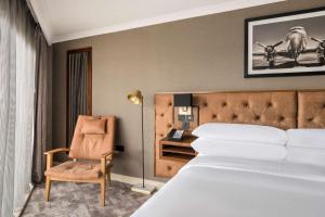 a bedroom with a bed and a chair and a desk at DoubleTree by Hilton Hotel Newcastle International Airport in Newcastle upon Tyne