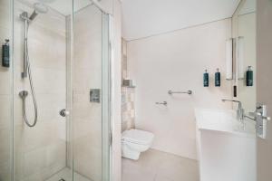 a bathroom with a shower and a toilet and a sink at DoubleTree by Hilton Hotel Newcastle International Airport in Newcastle upon Tyne